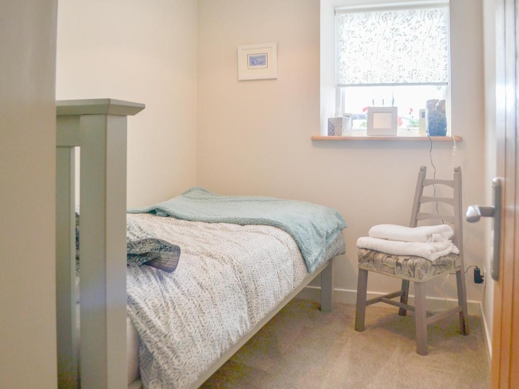 una piccola camera con letto e sedia di Mansefield Cottage a Boyndie