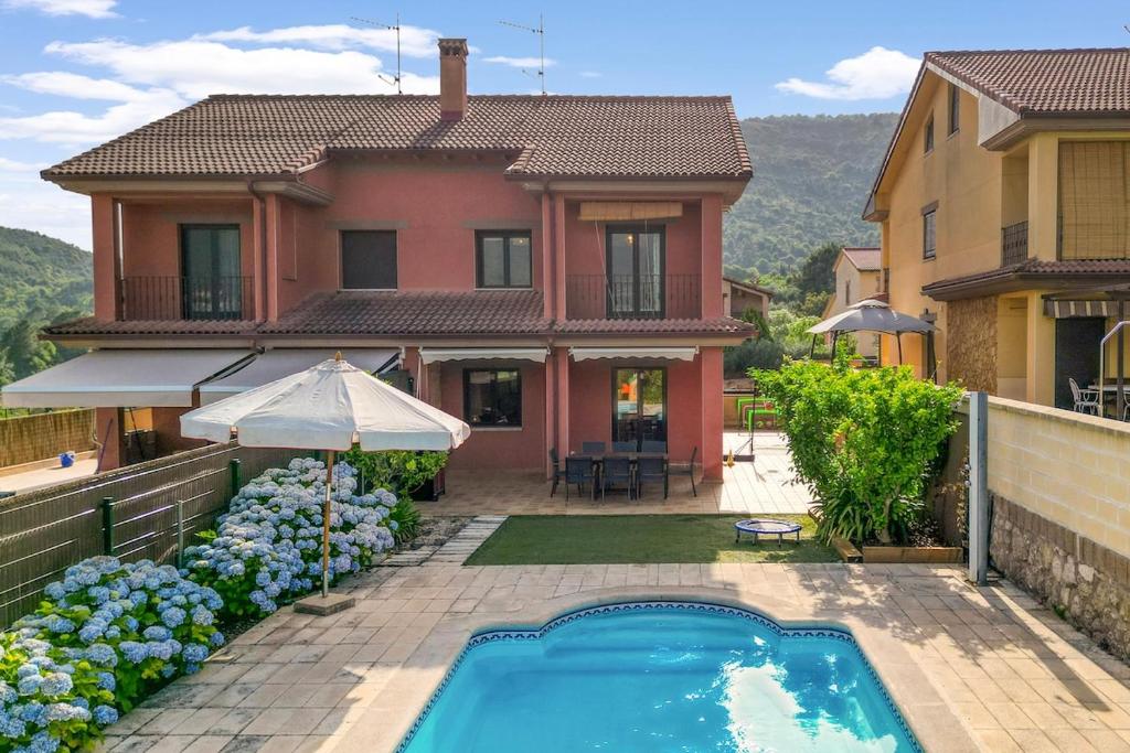 a house with a swimming pool in front of a house at Casa Gredos- Chimenea , Setas , BBQ , Relax in Mombeltrán