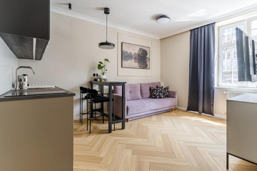 a living room with a couch and a table at Holy Spirit Street Apartments in Gdańsk