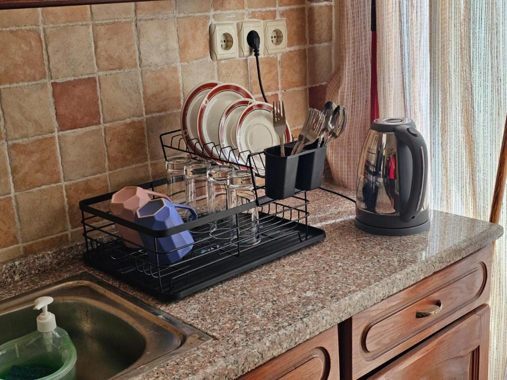 a kitchen counter with a dish rack next to a sink at Swemeh hills resort in Sowayma