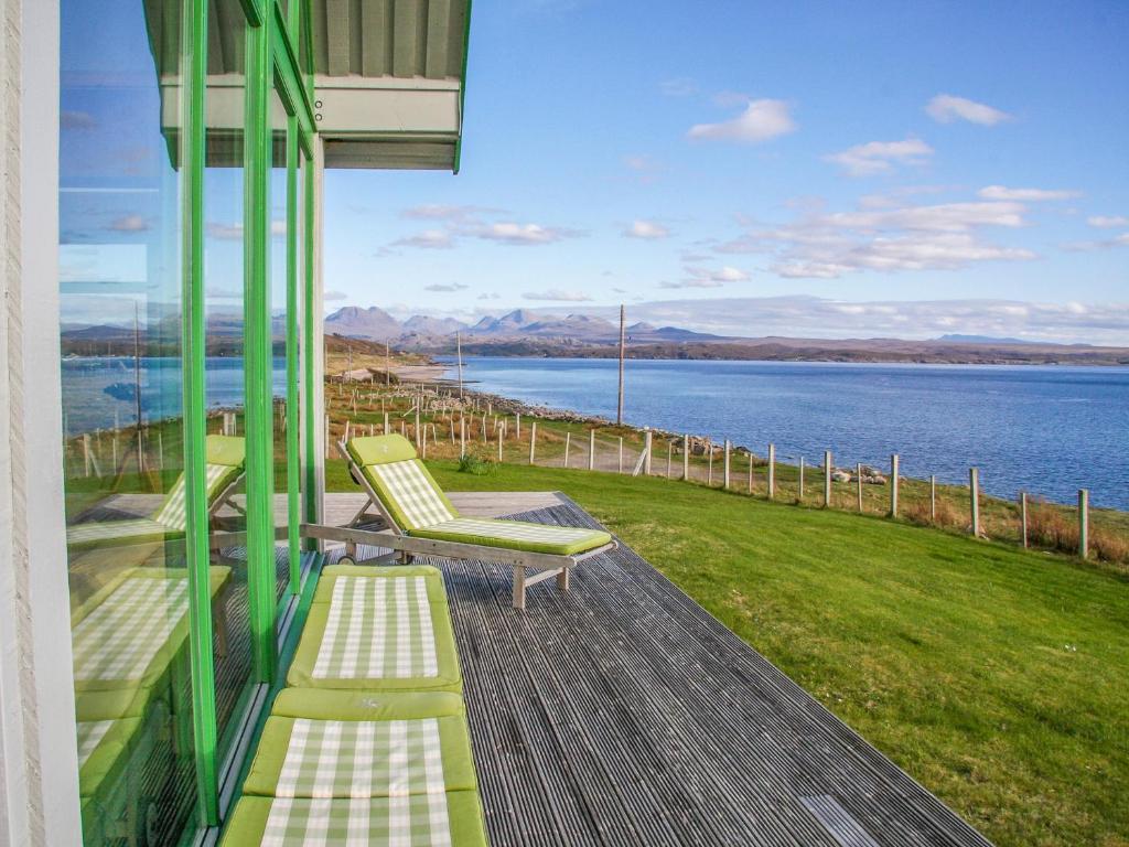 a porch with chairs and a view of the water at Longa House in Big Sand