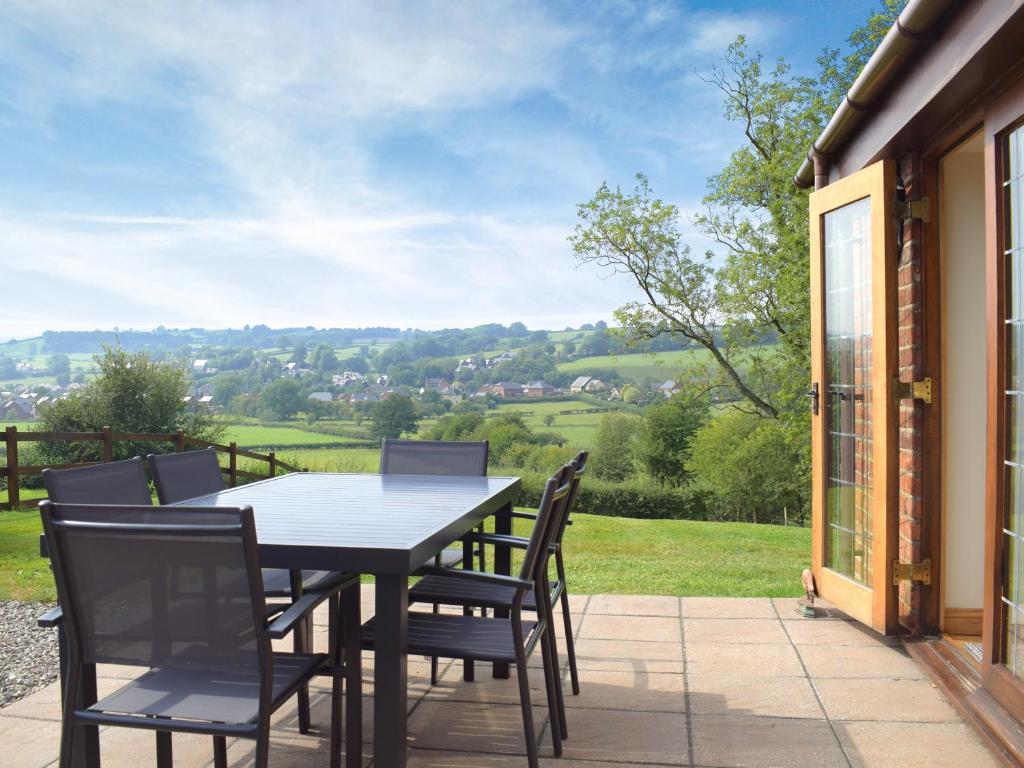a table and chairs on a patio with a view at Talog Barn-Uk31366 in Tregynon