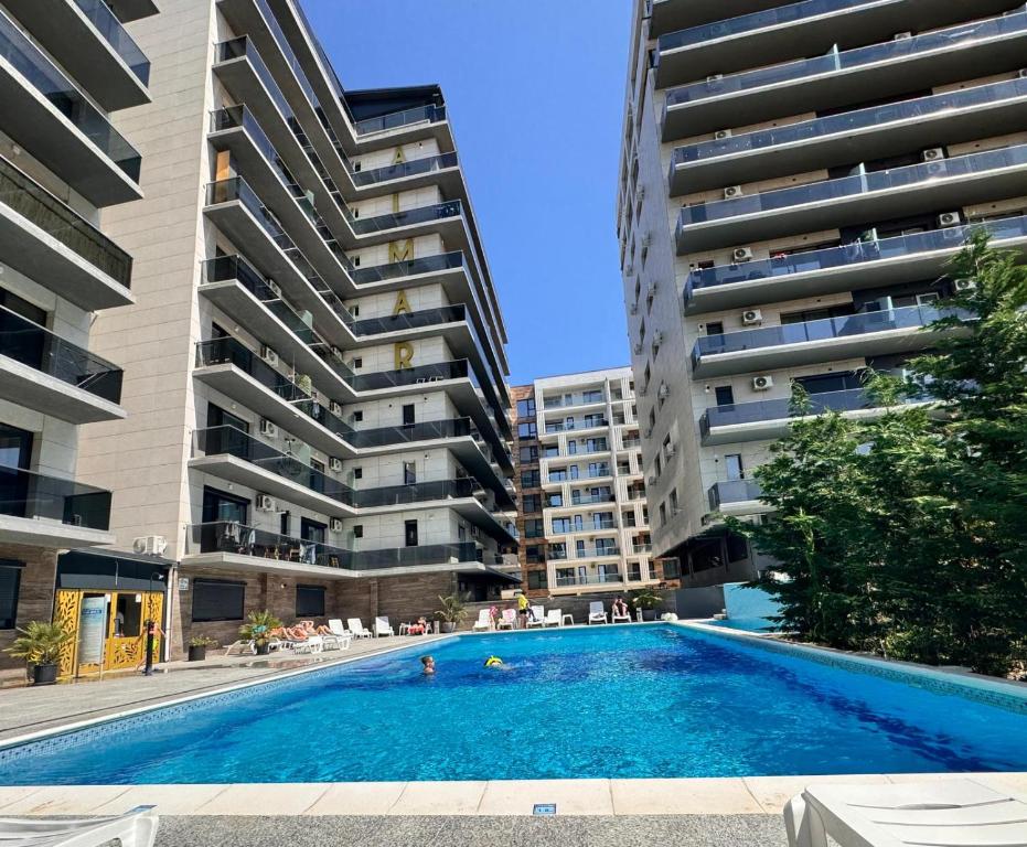 a swimming pool in front of two tall buildings at Ana Derol in Năvodari