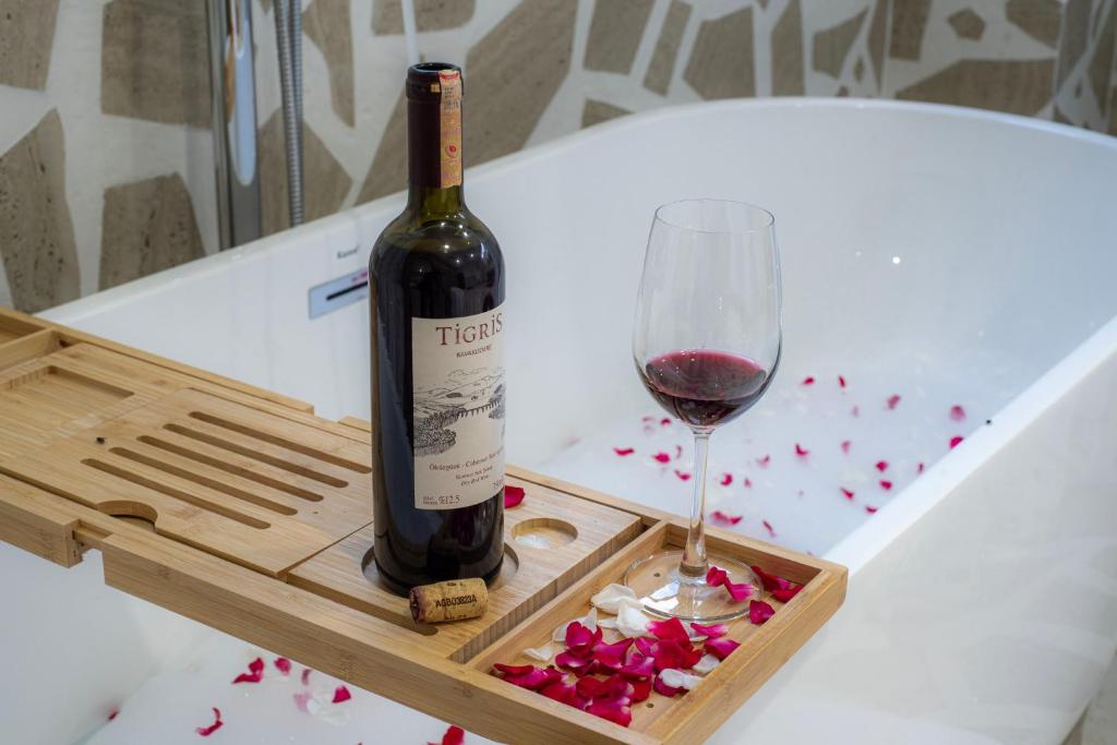 a bottle of wine and a glass on a table at ขุมทรัพย์โฮเทล KhumSaps Hotel in Ban Nong Kham