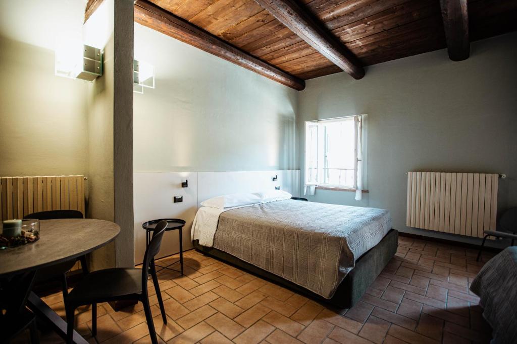a bedroom with a bed and a table in a room at Casa Gotica in Castelfranco Emilia