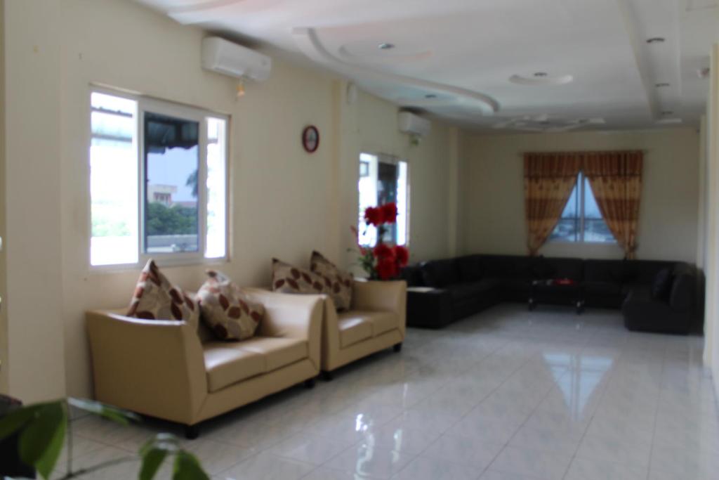 sala de estar con 2 sofás y sofá en Hotel Anda en Pematangsiantar