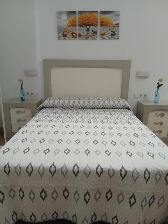a bedroom with a bed and a painting on the wall at Apartamentos Rey 2 in Prado del Rey