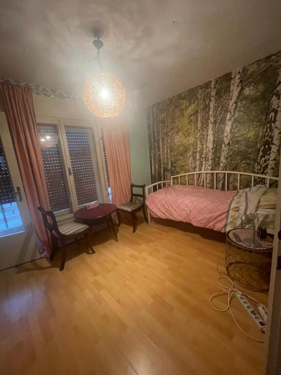 a bedroom with a bed and a table and chairs at Soba s pogledom na Dravski Park u Varaždinu in Varaždin