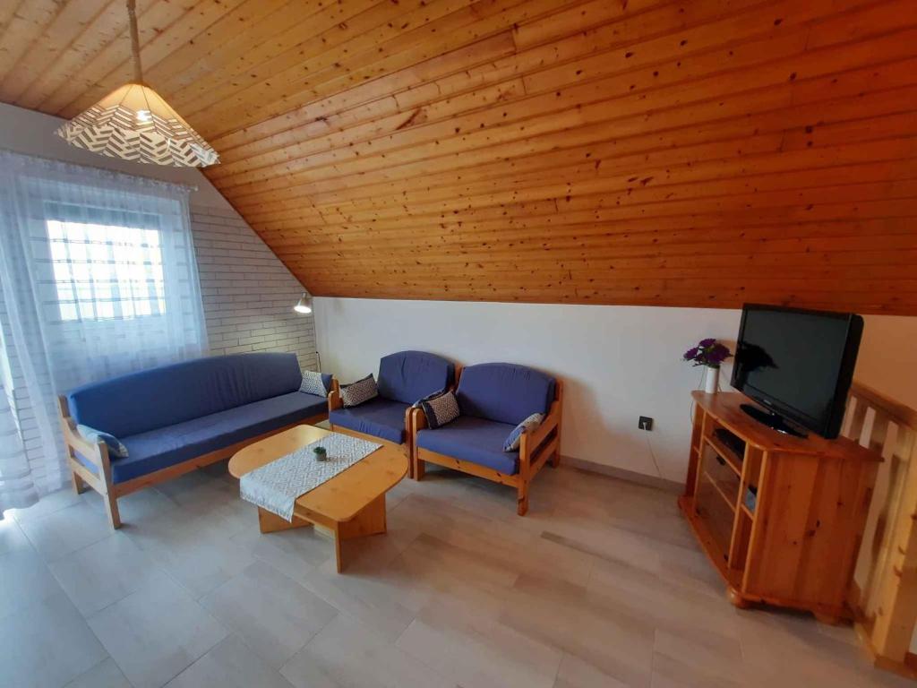 salon z 2 niebieskimi kanapami i telewizorem w obiekcie Holiday home in Balatongyörök 42694 w mieście Balatongyörök