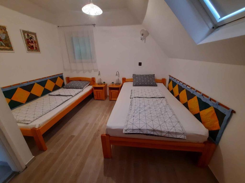 dwa łóżka w małym pokoju z oknem w obiekcie Holiday home in Balatongyörök 42694 w mieście Balatongyörök