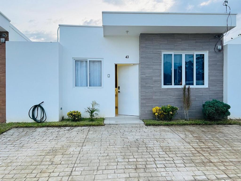 Una casa blanca con una puerta y una entrada de ladrillo. en Nueva san Miguel, en San Miguel