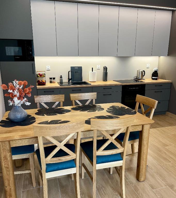 a kitchen with a wooden table and chairs at Apartament SOLMARINA in Iława