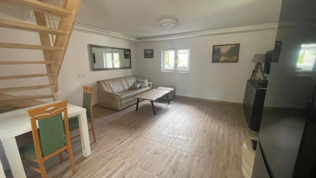een woonkamer met een bank en een tafel bij Domek w Limanowej in Limanowa