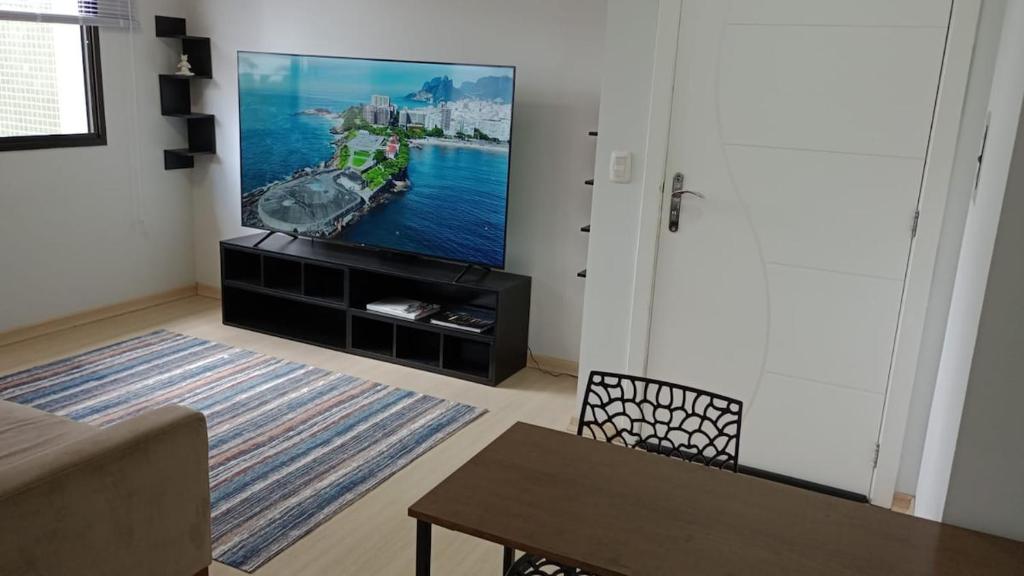 a living room with a flat screen tv on a wall at Studio Cinema 75 & Garage in Caxias do Sul
