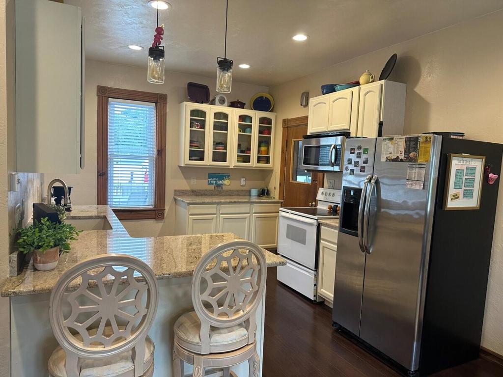 a kitchen with a stainless steel refrigerator and chairs at Charming Brick House in Little Chute
