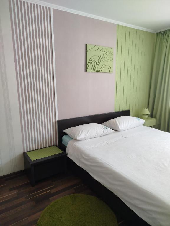 a bedroom with a large bed and a green rug at Elena in Rivne