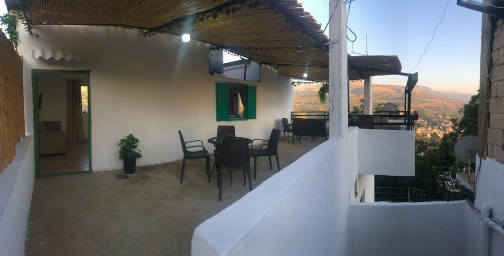 un balcone di una casa con tavolo e sedie di Ehden's Skyline a Ehden