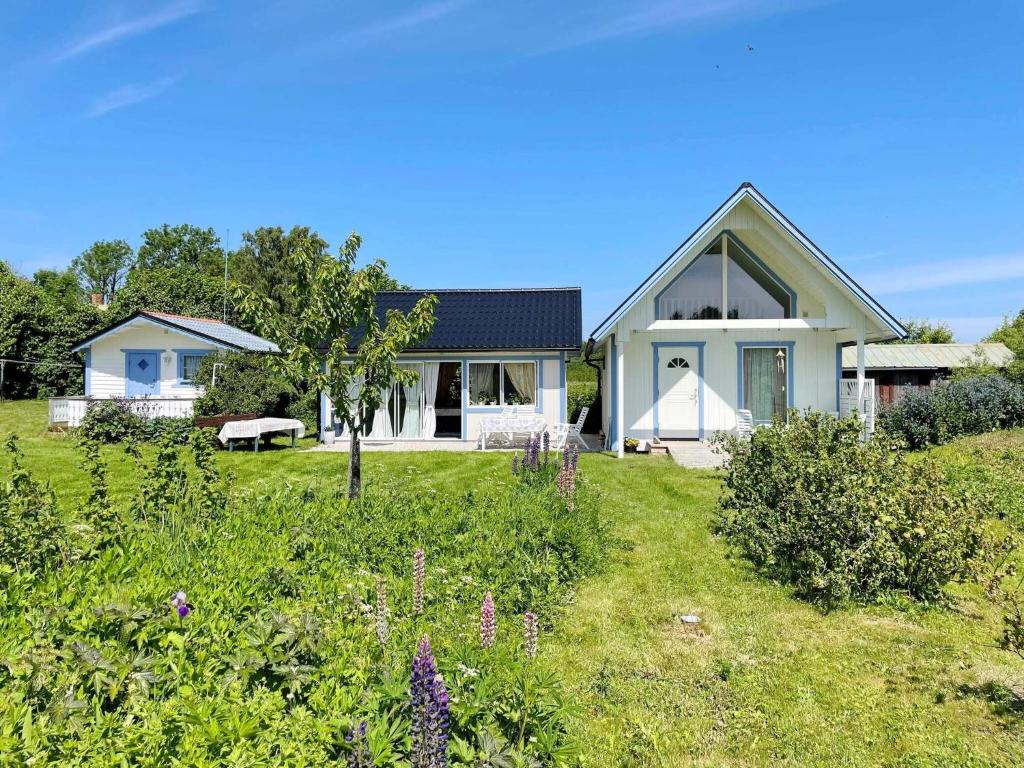 a white house with a garden in front of it at Charming Garden Cottage in Levide in Hemse