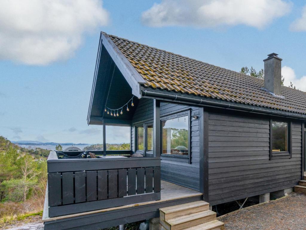 a small house with a large deck on a hill at Gunnarhytta, Valevåg in Valevåg