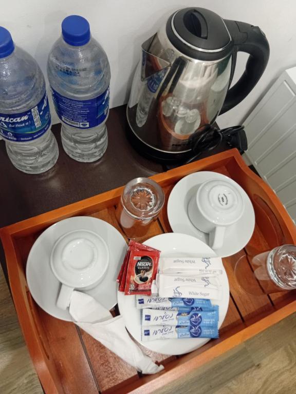bandeja con platos y botellas de agua en un mostrador en Ambuluwava Eco Resort, en Gampola