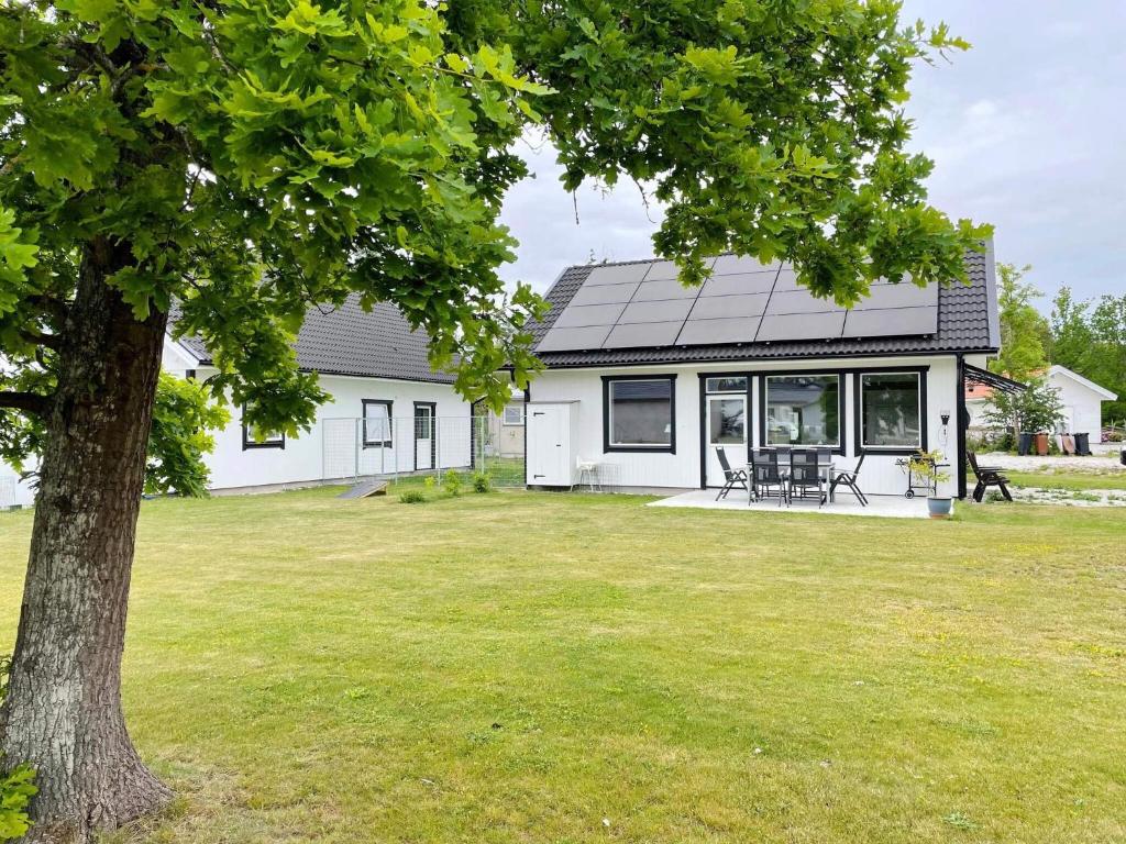 a white house with a tree in the yard at 4 star holiday home in Gotlands Tofta in Tofta
