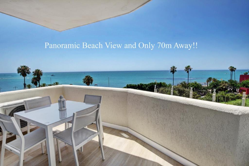 a white table and chairs on a balcony with the ocean at Beachfront Parque Paloma in Benalmádena