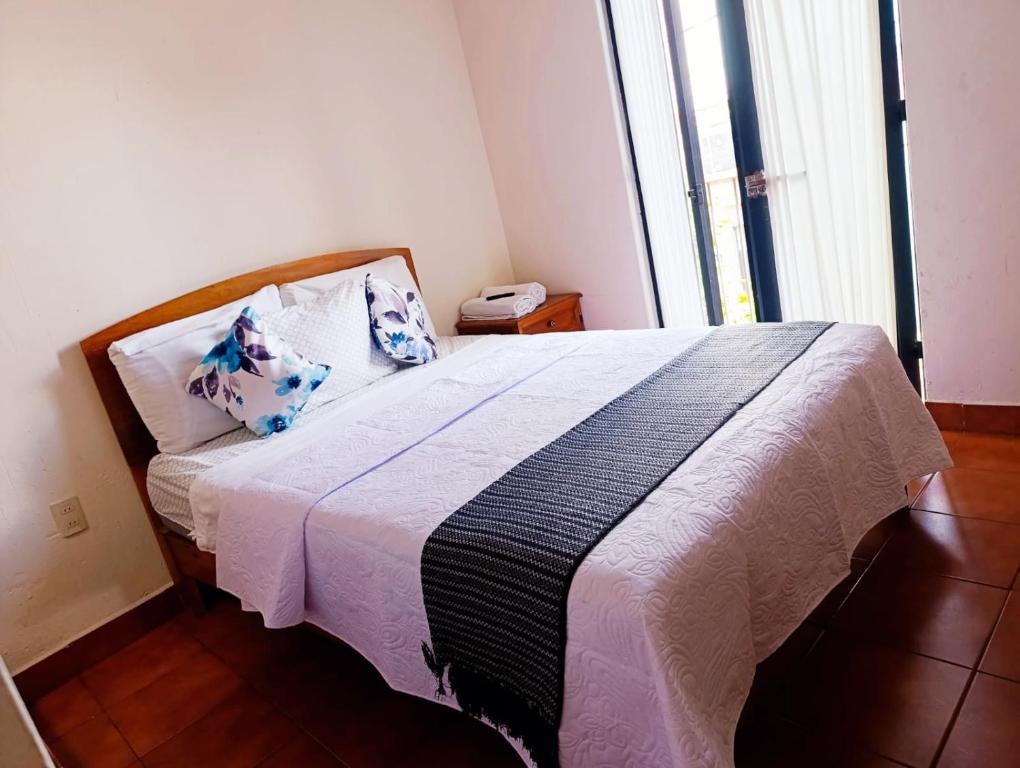 a bedroom with a bed with a black and white blanket at CASARU HOTEL OAXACA in Oaxaca City