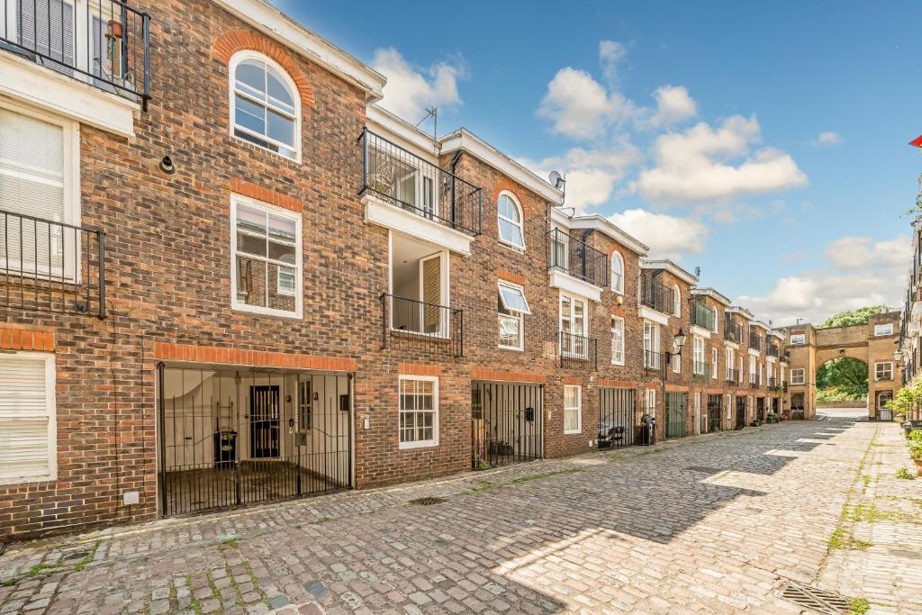 an empty street in front of a brick building at ELGIN MEWS NORTH beside Maida Vale tube and parking LONG TERM BOOKINGS in London