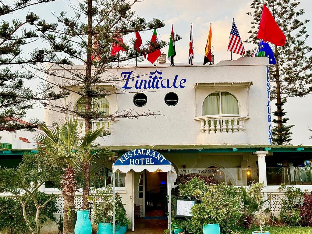 a building with flags on top of it at Hotel L'Initiale in Oualidia