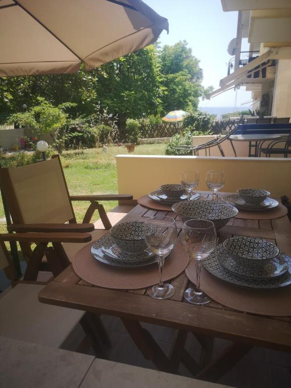a wooden table with plates and wine glasses on it at Noka Nikiti in Nikiti