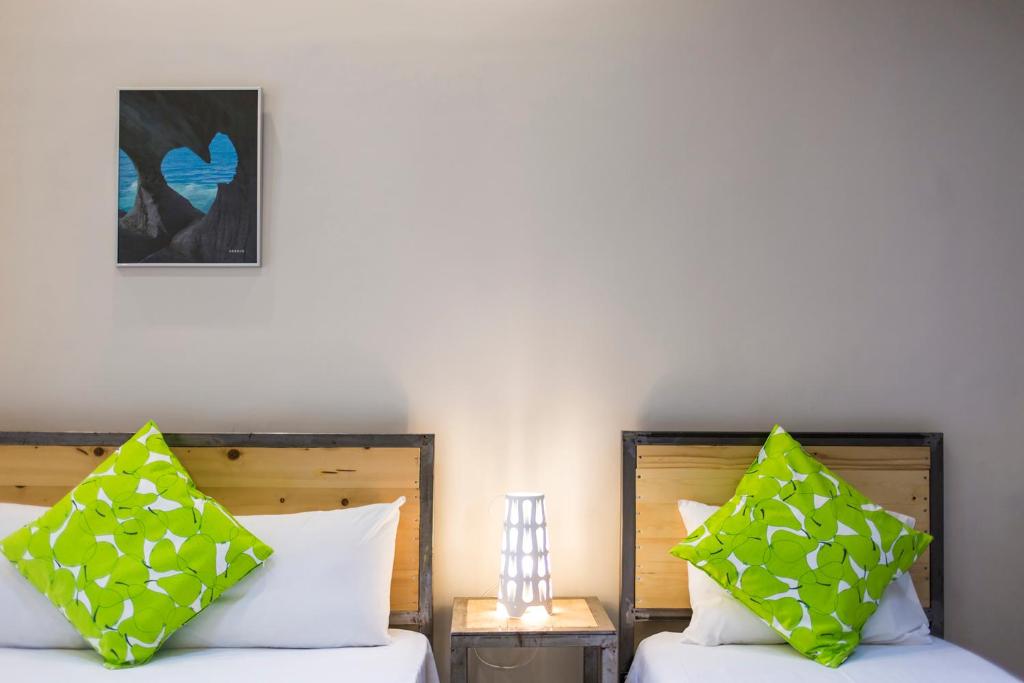 2 camas con almohadas verdes y blancas en una habitación en Zonita Guest House, en Nea Plagia