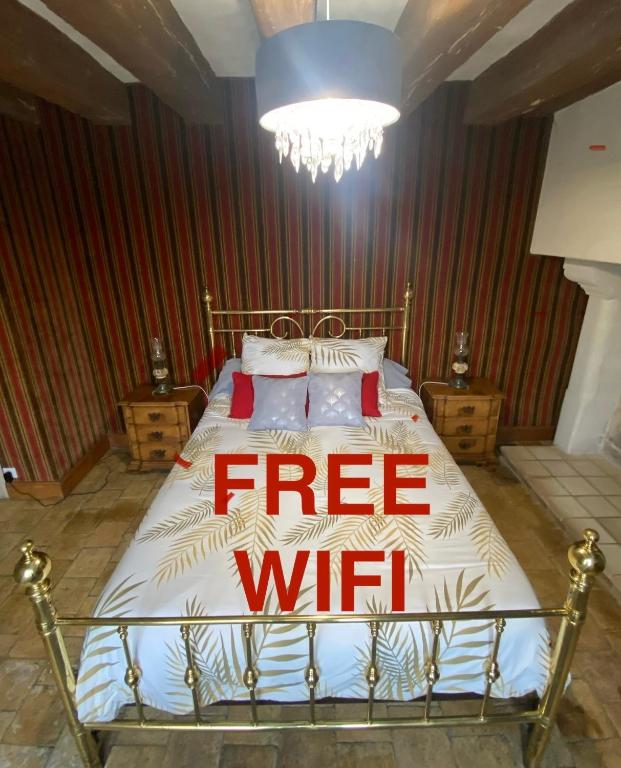 un panneau wifi gratuit sur un lit dans une chambre dans l'établissement La Grange d Ave, à Luynes