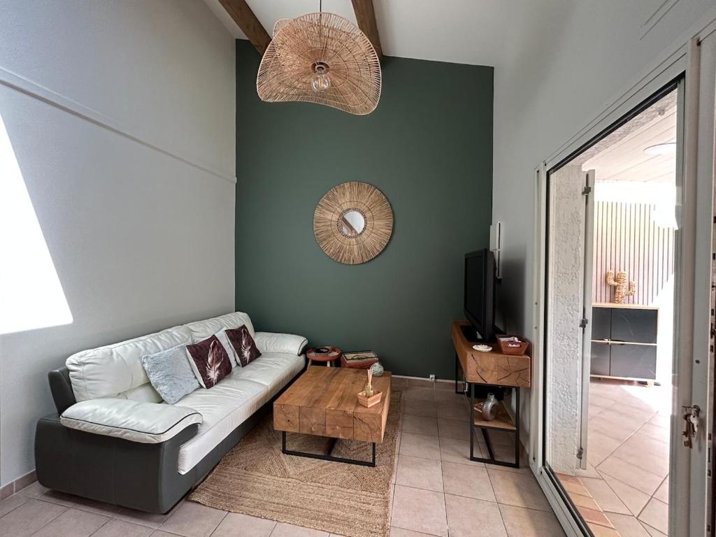 un soggiorno con un divano e un tavolo di Villa cosy à 200 m de la mer a Cap d'Agde