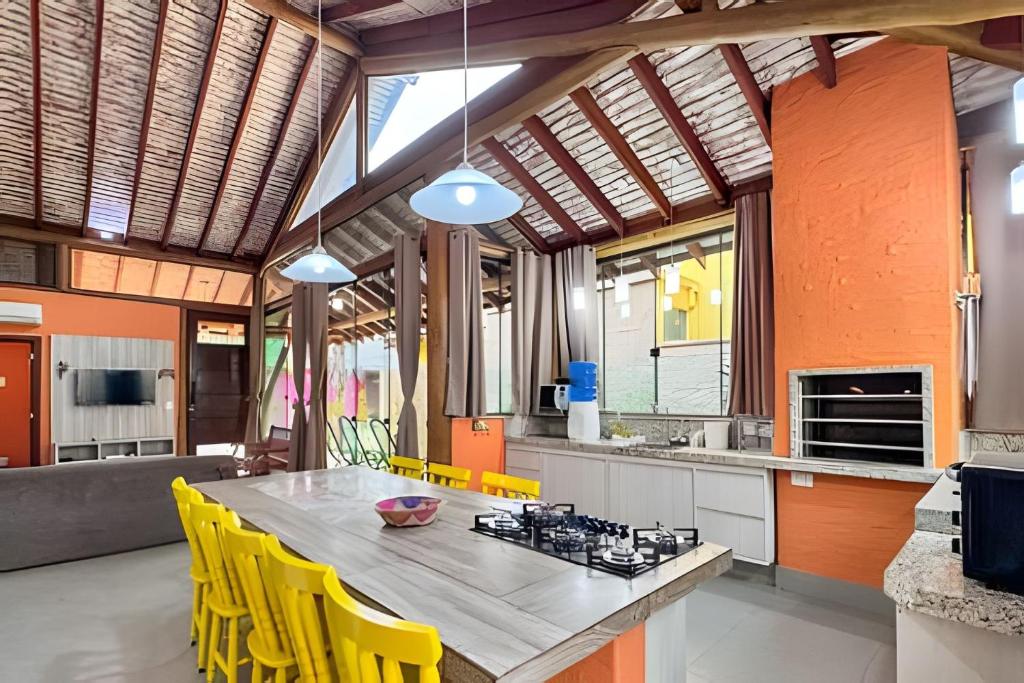 an open kitchen with a table and yellow chairs at Casa no Centro de Bonito no condomínio Eco Bonito in Bonito