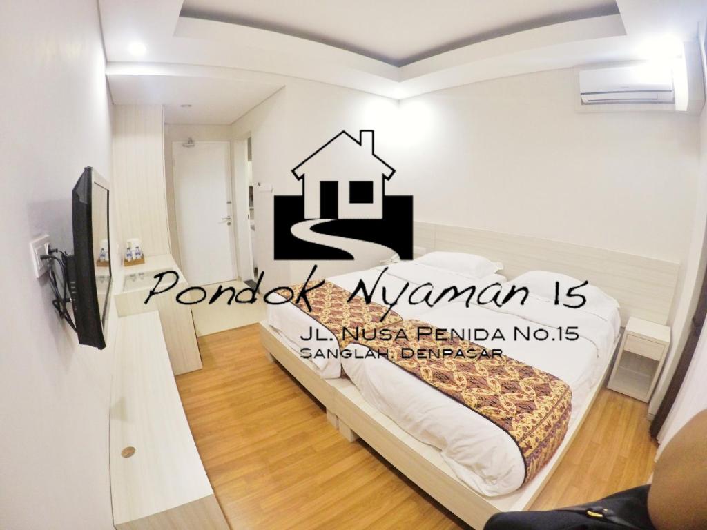 Un dormitorio con una cama con una pegatina de la casa. en Pondok Nyaman 15, en Denpasar