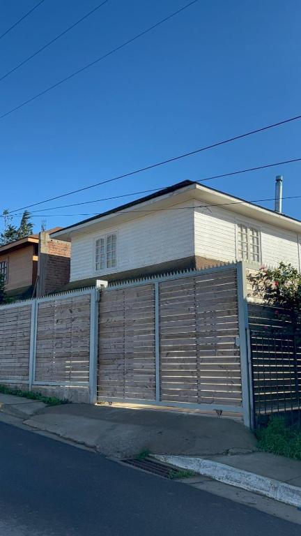 a house with a wooden fence in front of it at Casa en Pichilemu acogedora y amplia Casa Lile in Pichilemu