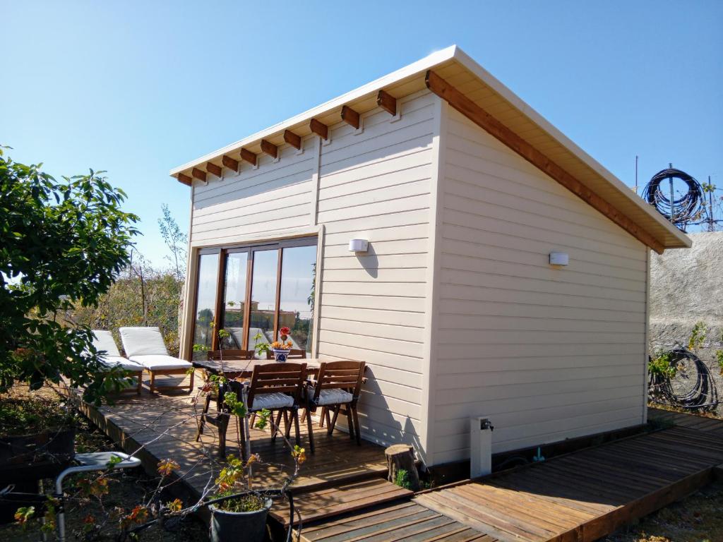 a white shed with a table and chairs on a deck at El Cornical Luxury Bungalows in Arafo