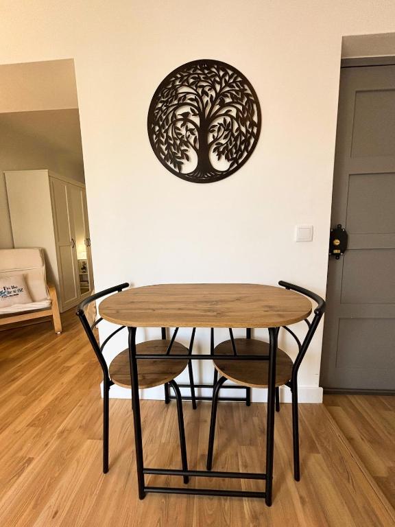 a table with two chairs and a tree on the wall at Casa Miká in Parede