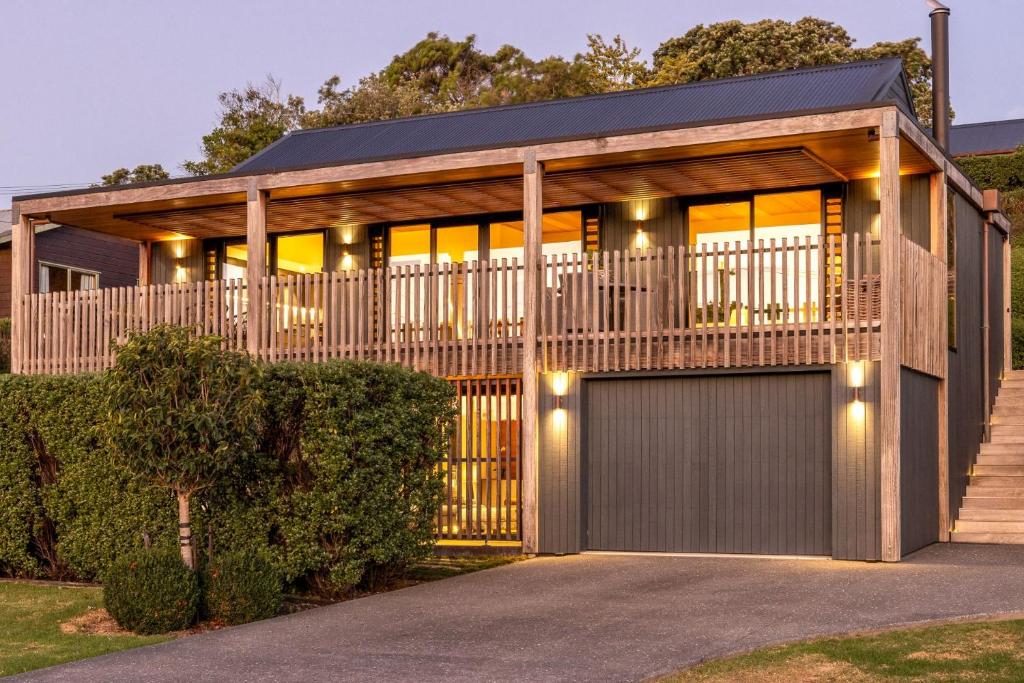 una casa con una puerta y un garaje en Moa Whare - Stay Waiheke, en Waiheke Island
