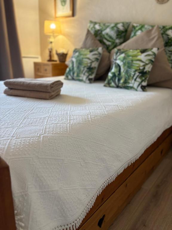 a bed with a white mattress with pillows on it at Chambre Bohème chic avec jacuzzi in Liouc