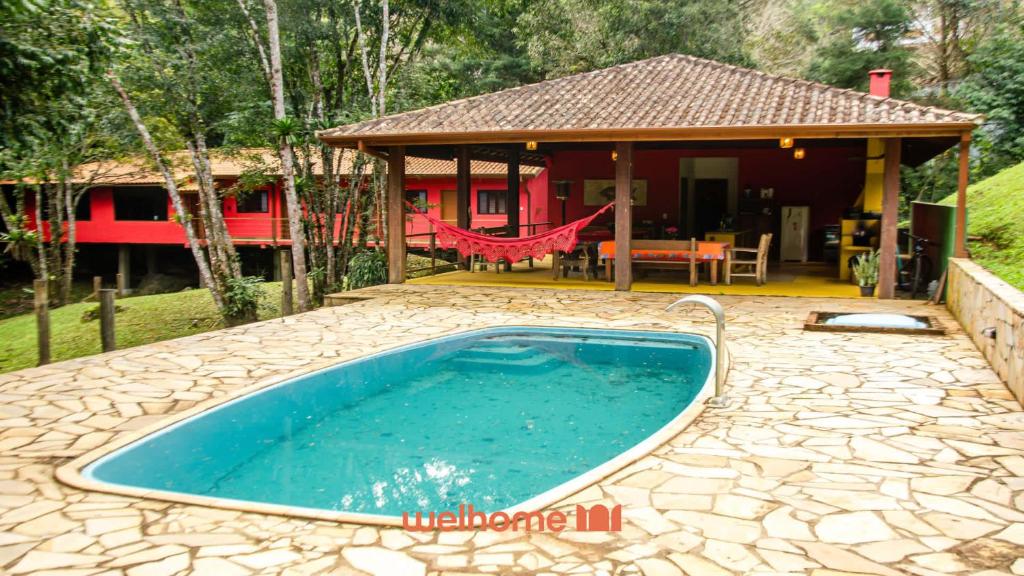 a swimming pool in front of a house at Casa em Sao Francisco Xavier com Piscina in São José dos Campos