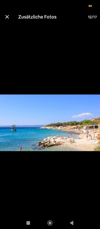 un écran de télévision avec une image d'une plage dans l'établissement Etagenwohnung Apartment Sara, à Novi Vinodolski