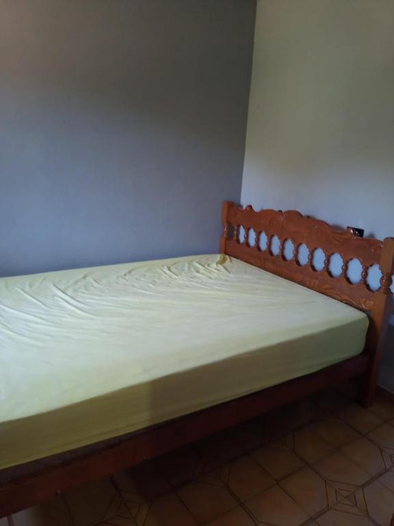 a wooden bed in a room with at Pé na roça in Camanducaia