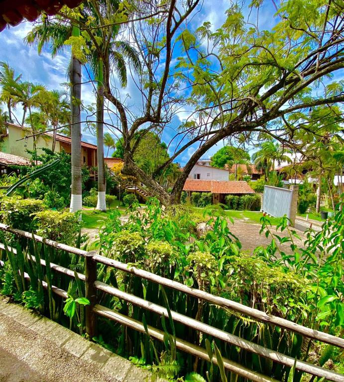 a fence in front of a park with trees and flowers at Pousada Praia da Pipa in Pipa