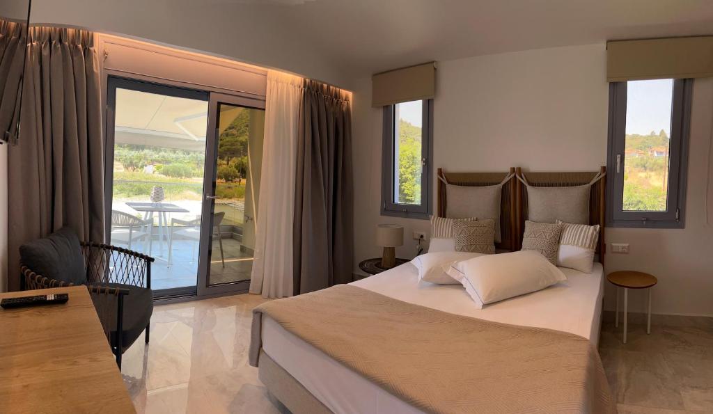 a bedroom with a large bed and a balcony at Notia Luxury Living in Porto Koufo