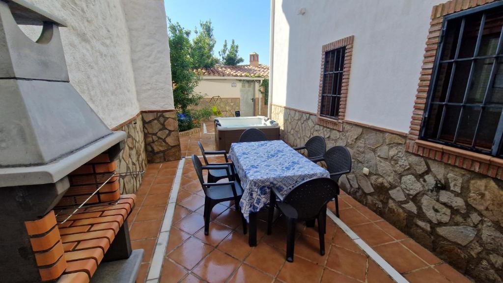 a patio with a table and chairs on a stone wall at Casa los caminos de GRANADA in Cozvíjar