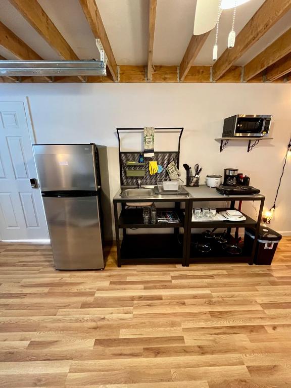 Una cocina con refrigerador de acero inoxidable y una mesa. en NYC-Style Loft with Secret Entrance - Just 6 Miles from Times Square, en North Bergen