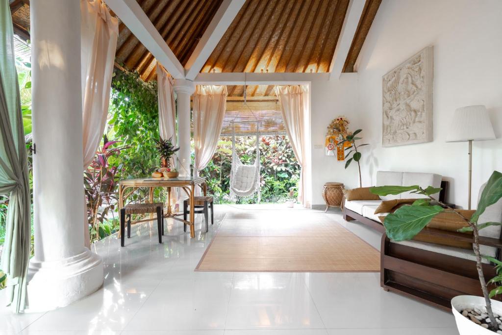 a living room with a couch and a table at Vastu Family villa in Ubud