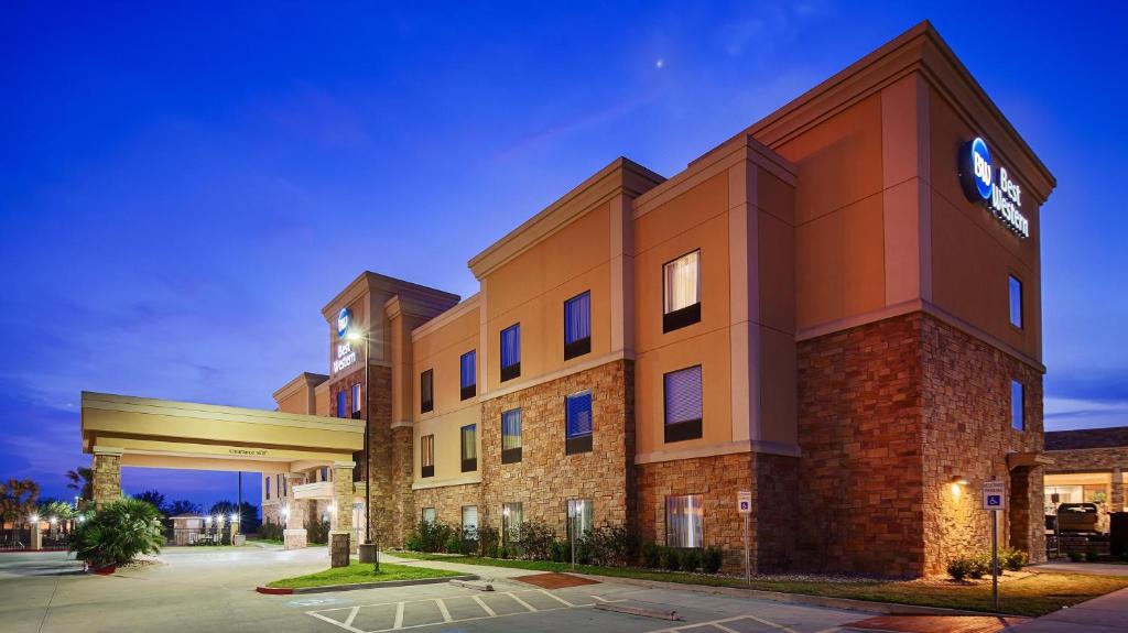 Un gran edificio de ladrillo con un reloj encima. en Best Western Bastrop Pines Inn, en Bastrop