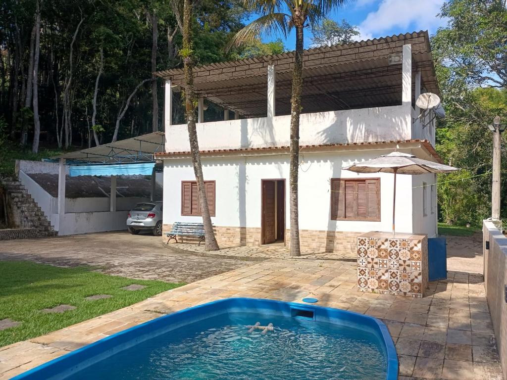 a swimming pool in front of a house at Sítio Cantinho da Natureza in Piraí